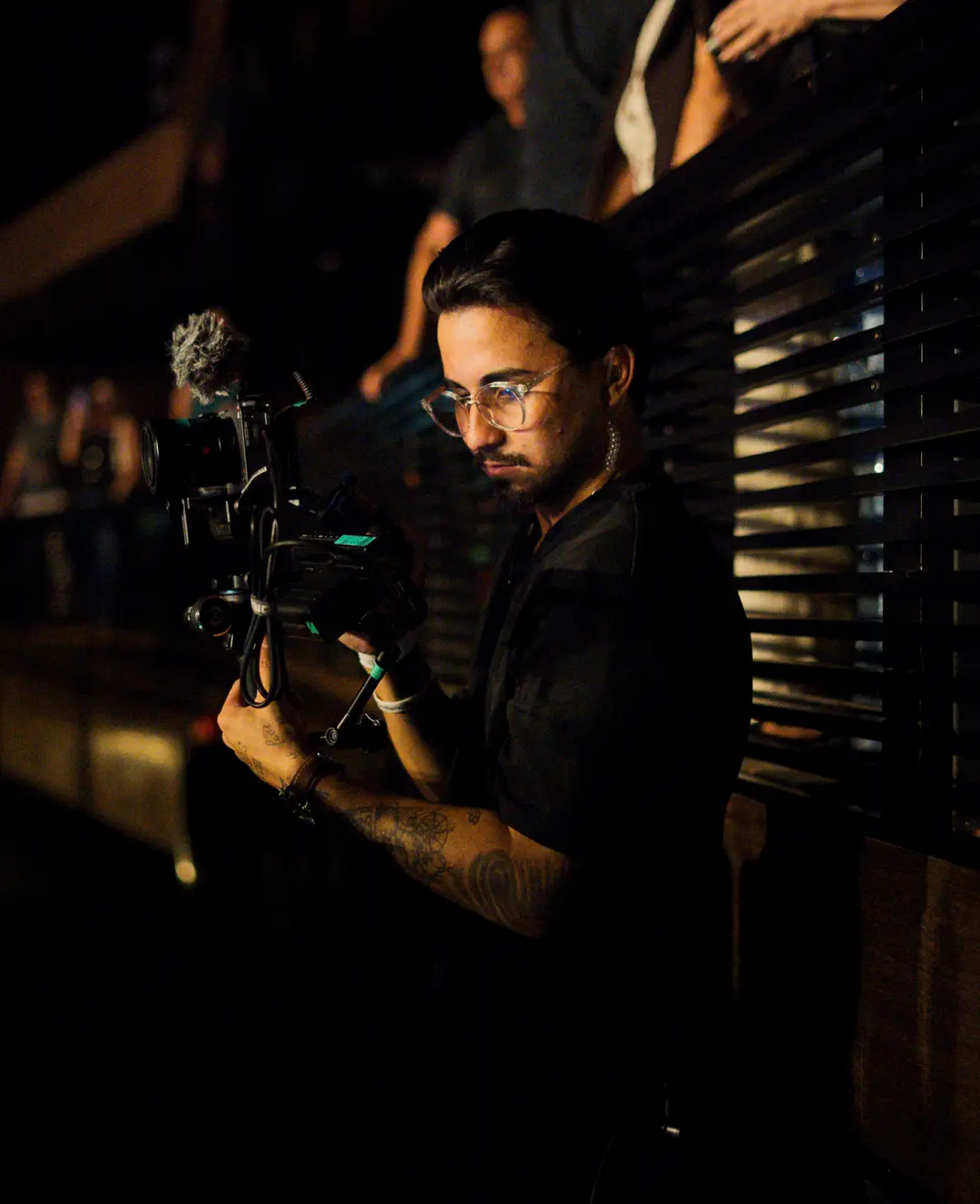 Cinegrafista com a câmera no ombro sob luz dourada